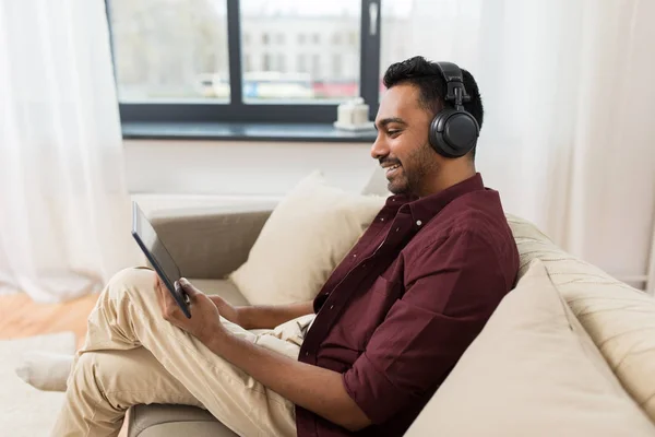 Homem em telefones com tablet pc ouvindo música — Fotografia de Stock