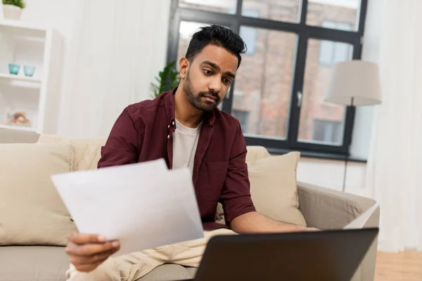 Upset man with laptop and papers at home — Stock Photo, Image