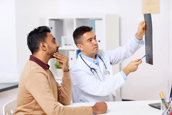 医生与 x-射线和男性患者在诊所 — 图库照片