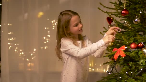 Gelukkig meisje versieren kerstboom thuis — Stockvideo