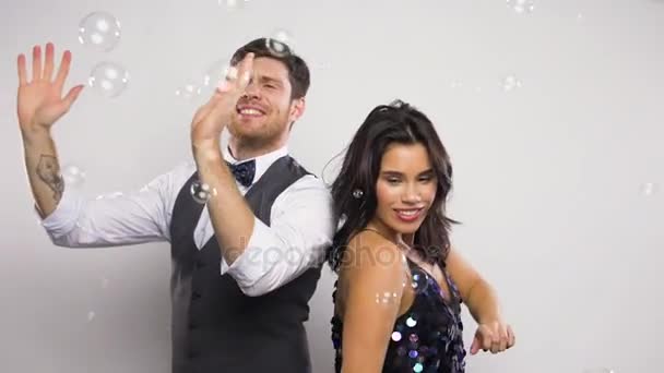 Счастливая пара танцует в мыльных пузырях на вечеринке — стоковое видео