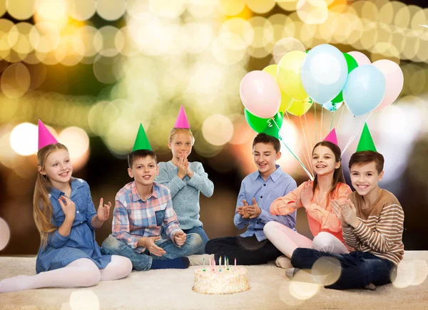 Ευτυχισμένα παιδιά στο κόμμα καπέλα με τούρτα γενεθλίων — Φωτογραφία Αρχείου