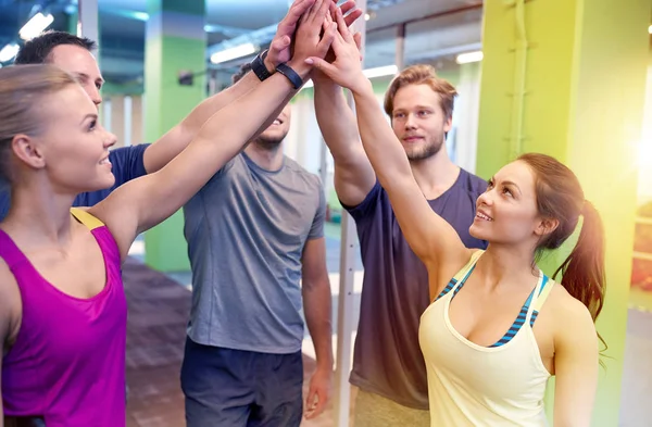 Groep gelukkige vrienden maken hoge vijf in sportschool — Stockfoto