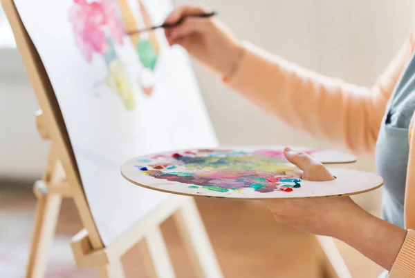 Artista com paleta e pintura pincel no estúdio — Fotografia de Stock