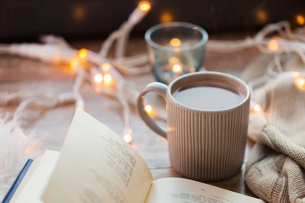 Libro y taza de café o chocolate caliente en la mesa — Foto de Stock