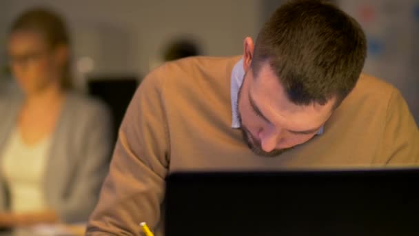 Trabajadores de oficina con ordenador portátil trabajando por la noche — Vídeo de stock