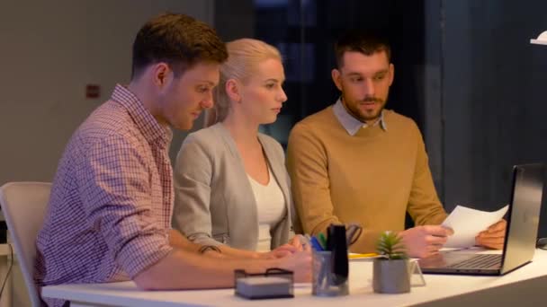 Бизнес-команда с ноутбуком, работающая в ночном офисе — стоковое видео