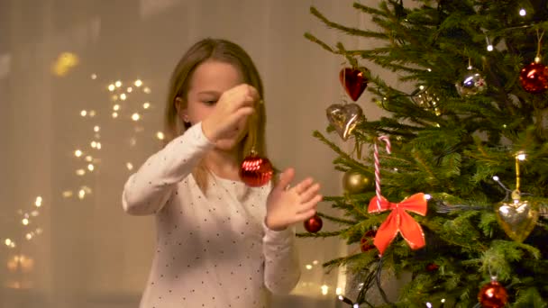 Mutlu kız evde Noel ağacı süslüyor. — Stok video
