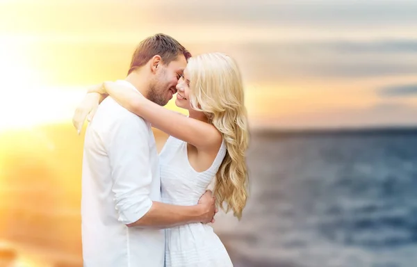 Счастливая пара обнимается и целуется на летнем пляже — стоковое фото