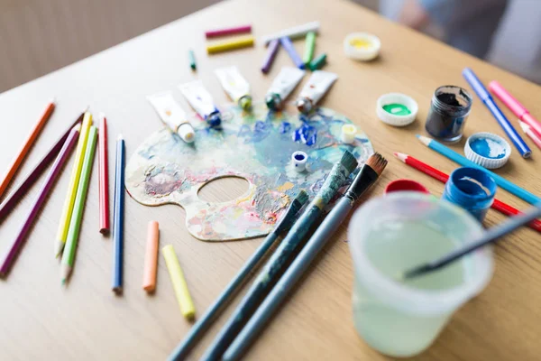 Color palette, brushes and paint tubes on table — Stock Photo, Image