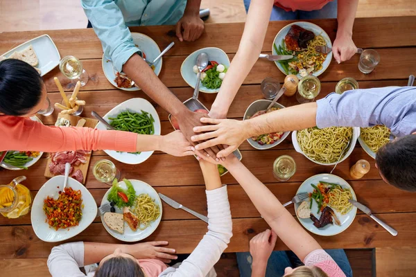 Les gens se tenant la main sur la table avec de la nourriture — Photo