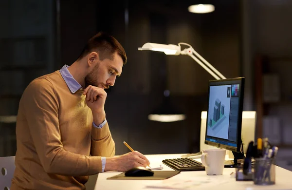 Mann mit Notizblock arbeitet nachts im Büro — Stockfoto