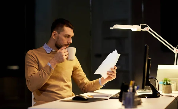 Man with papers and coffee working at night office — Stock Photo, Image