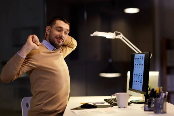 Uomo con computer che lavora fino a tardi all'ufficio notturno — Foto Stock