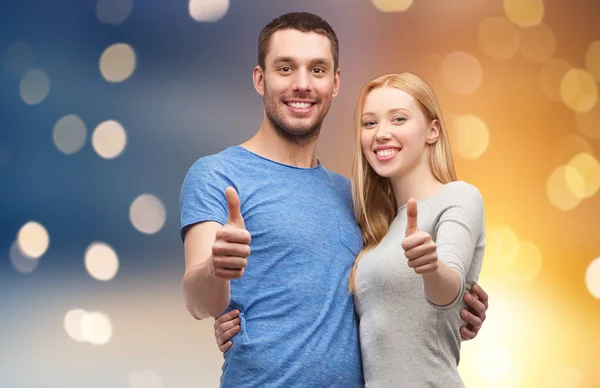 Happy couple hugging and showing thumbs up — Stock Photo, Image