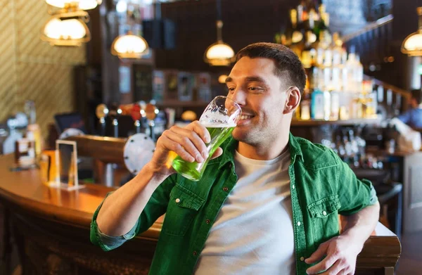 Homem bebendo cerveja verde no bar ou pub — Fotografia de Stock