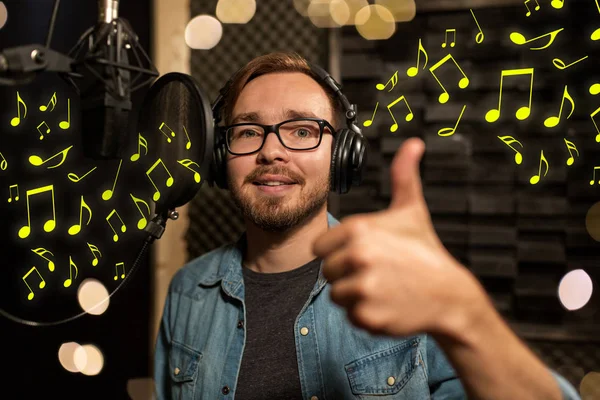 Uomo con le cuffie che canta in studio di registrazione — Foto Stock