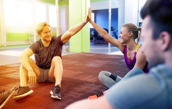 Group of happy friends making high five in gym — Stock Photo, Image