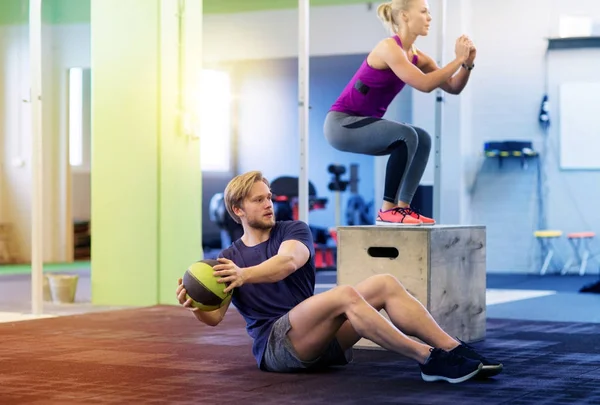 Женщина и мужчина с мячом медицины упражнения в тренажерном зале — стоковое фото