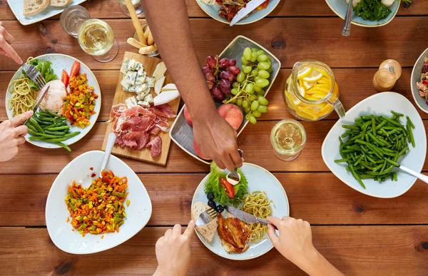 Groupe de personnes mangeant à table avec de la nourriture — Photo