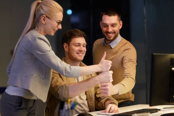 Equipo de negocios haciendo pulgares hacia arriba gesto en la oficina — Foto de Stock