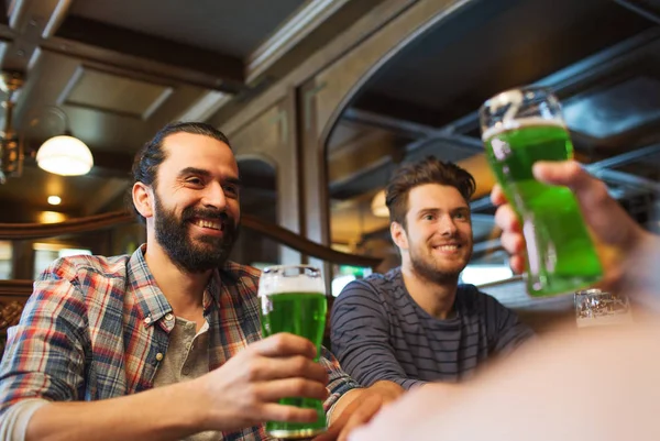 Amigos varones bebiendo cerveza verde en el bar o pub — Foto de Stock