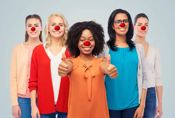 Grupp kvinnor visar tummen upp på röd näsa dag — Stockfoto