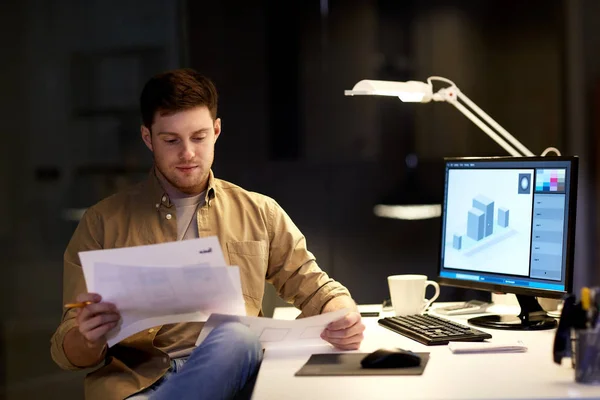 Designer with papers working at night office — Stock Photo, Image