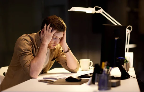 Людина з комп'ютером працює пізно в нічному офісі — стокове фото
