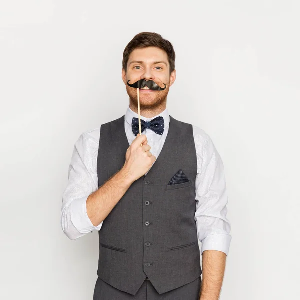 Happy young man with fake mustache at party — Stock Photo, Image