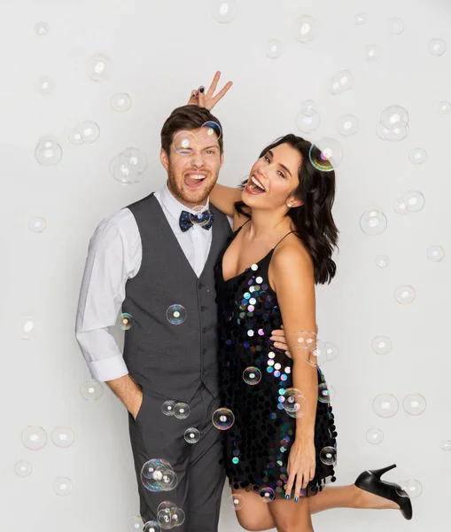 Щаслива пара обіймає мильні бульбашки на вечірці — стокове фото