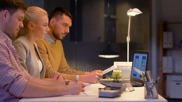 Бизнес-команда с ноутбуком, работающая в ночном офисе — стоковое видео