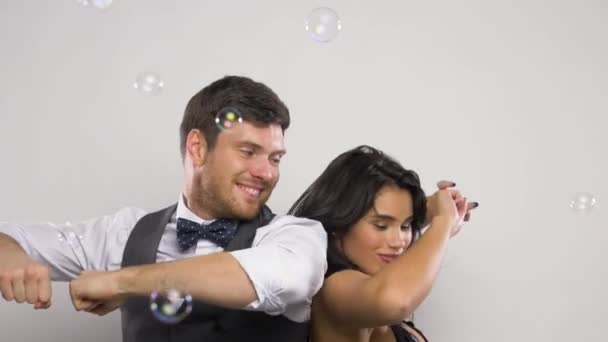 Feliz casal dançando em bolhas de sabão na festa — Vídeo de Stock