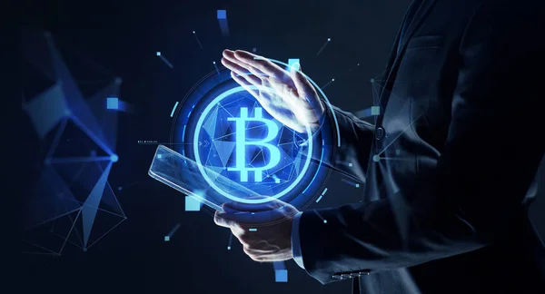 Businessman with tablet pc and bitcoin hologram — Stock Photo, Image