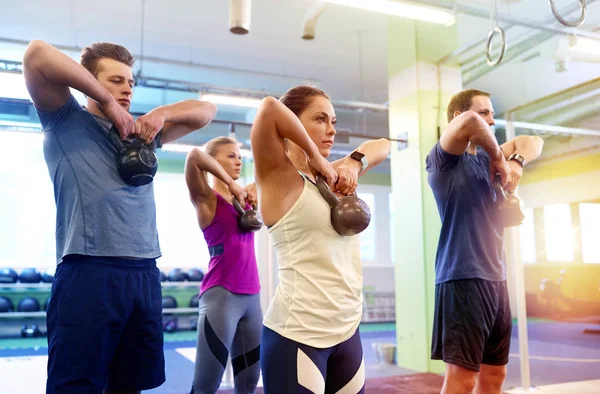 一群人与壶铃在健身房锻炼身体 — 图库照片