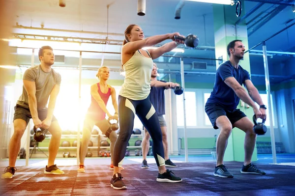 Grupp människor med kettlebells träning i gym — Stockfoto