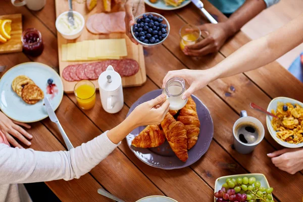 Pessoas tomando café da manhã à mesa com alimentos — Fotografia de Stock