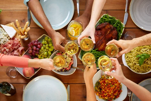 Mains cliquetis verres à vin sur la table avec de la nourriture — Photo