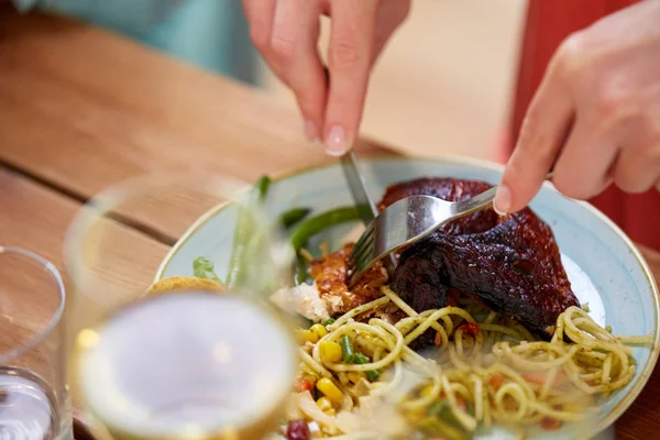 Hands of woman with fork eating roast chicken — Stock Photo, Image