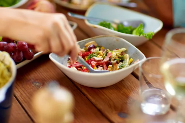 Pessoas comendo salada à mesa com alimentos — Fotografia de Stock