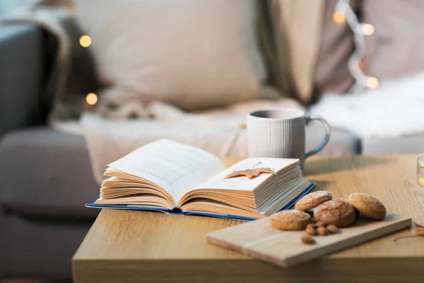 Книга с осенним листочком, кулинария и чай на столе — стоковое фото