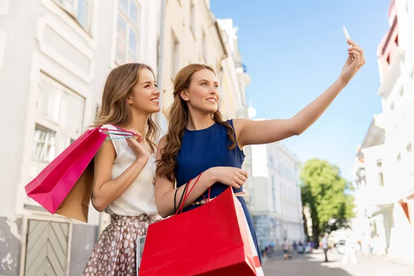 Mulheres fazendo compras e tirando selfie por smartphone — Fotografia de Stock