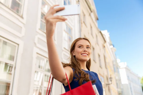 Woman shopping and taking selfie by smartphone — Stock Photo, Image