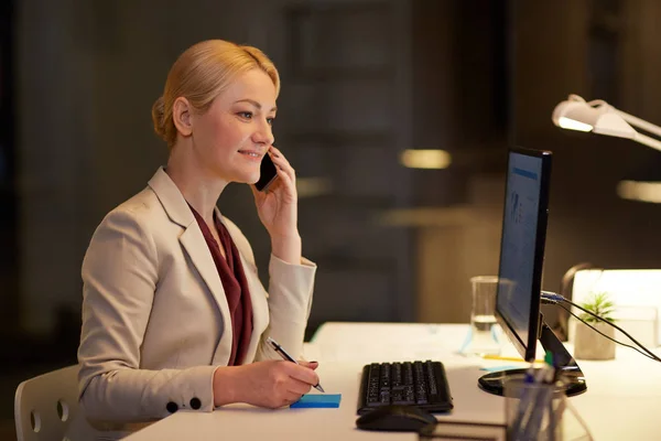 Mujer de negocios llamando a sartphone en la oficina nocturna — Foto de Stock