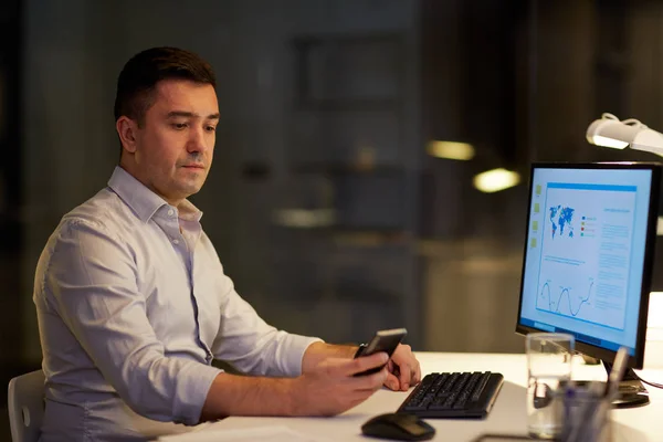 Man with smartphone working late at night office — Stock Photo, Image