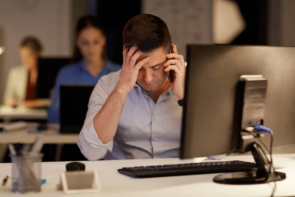 Affärsman som ringer på sartphone på natten kontor — Stockfoto