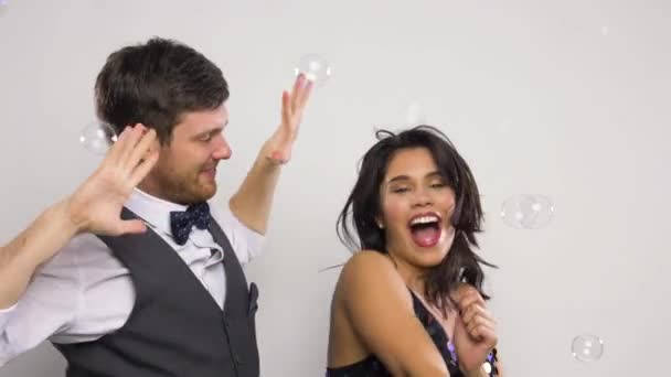 Feliz pareja bailando en pompas de jabón en fiesta — Vídeo de stock