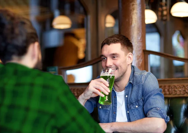 Male friends drinking green beer at bar or pub — Stock Photo, Image