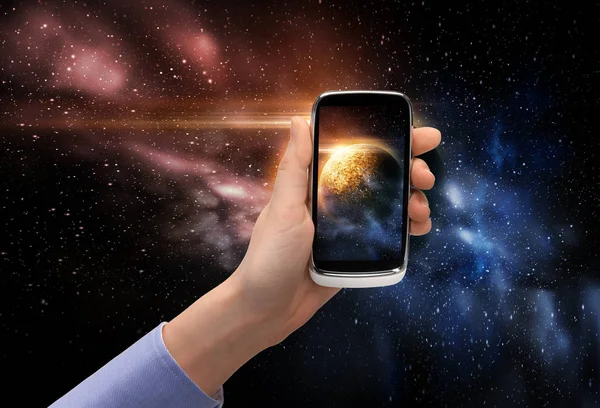 Overhandigen met planeet op smartphone scherm ruimte — Stockfoto