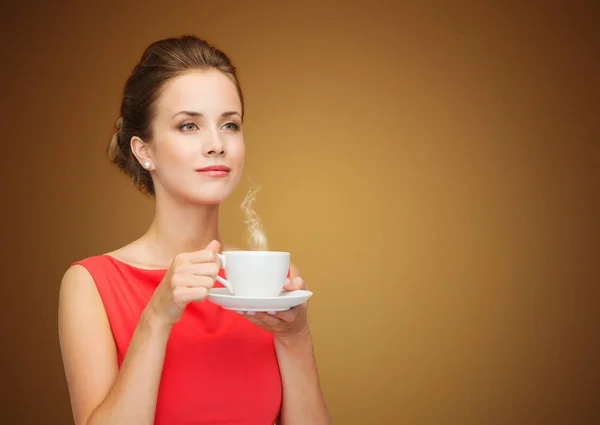 Belle femme en robe rouge avec tasse de café — Photo